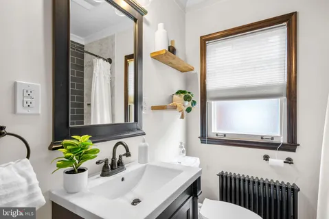 a bathroom with a sink a mirror and a window