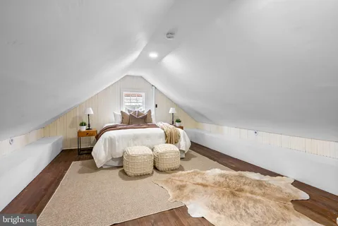a view of a bedroom with wooden floor and window