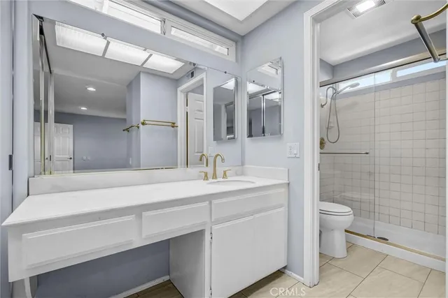 a bathroom with a sink a toilet a mirror and shower