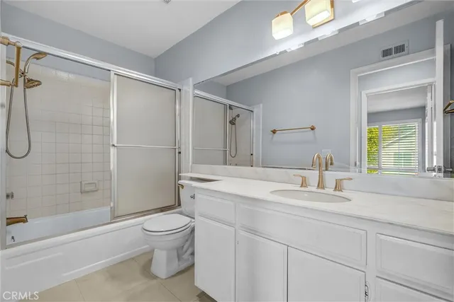 a bathroom with a sink a toilet and a large mirror