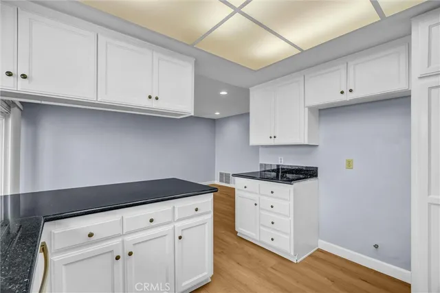 a kitchen with granite countertop white cabinets and white appliances