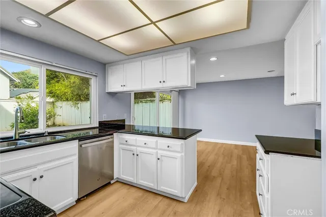 a kitchen with granite countertop a sink stainless steel appliances and cabinets