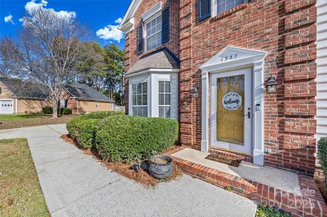 front view of a brick house with a small yard