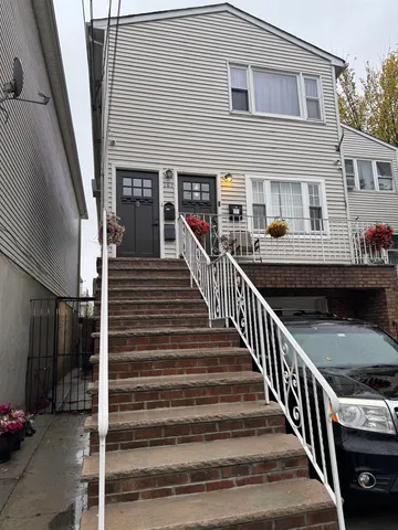 a view of a house with wooden stairs and a table and chairs
