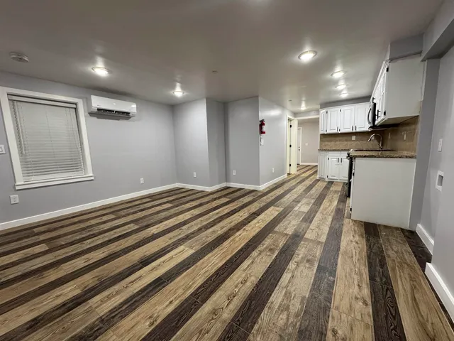 a view of a bedroom with wooden floor and a sink