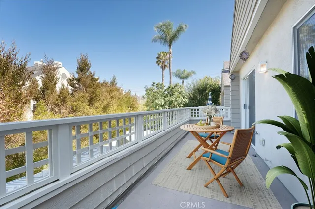 a roof deck with table and chairs and potted plants