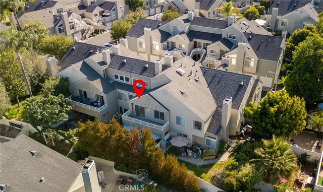 an aerial view of a residential houses with outdoor space and trees