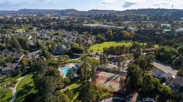 an aerial view of residential houses with outdoor space and trees