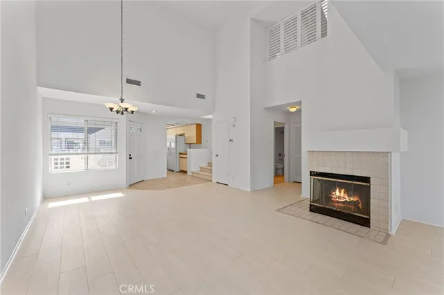 an empty room with windows and fireplace