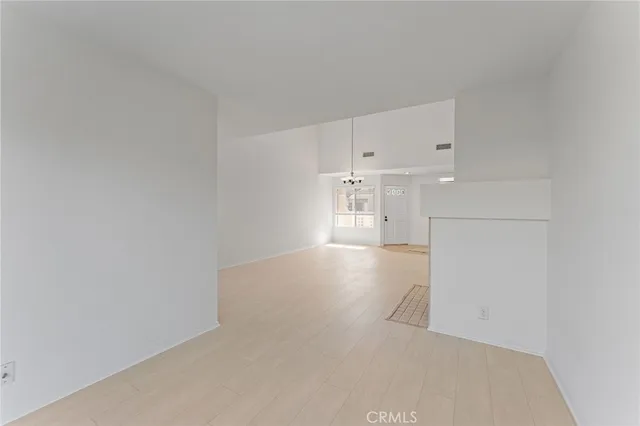 a view of a kitchen with refrigerator and white cabinets