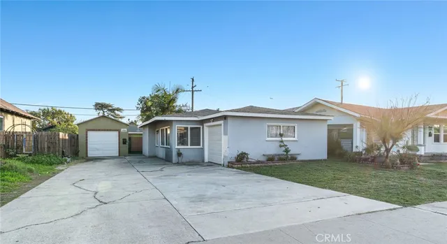 a view of a house with a yard and large tree