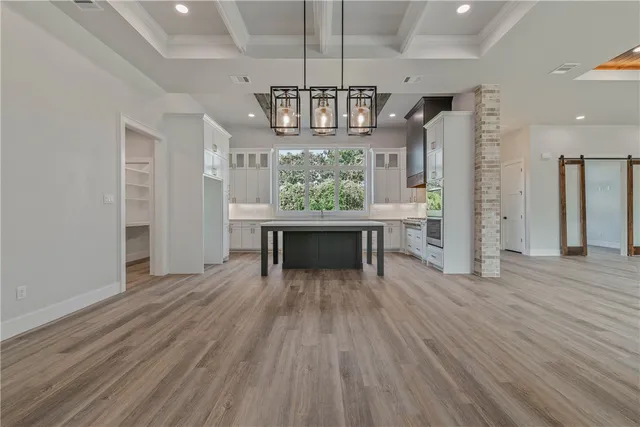 a view of a livingroom with a fireplace wooden floor and chandelier