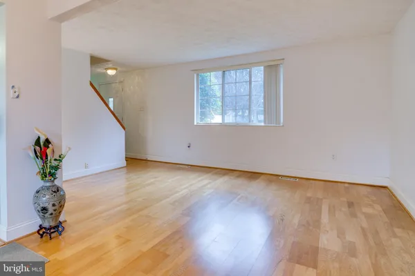 a view of a room with wooden floor potted plant and windows