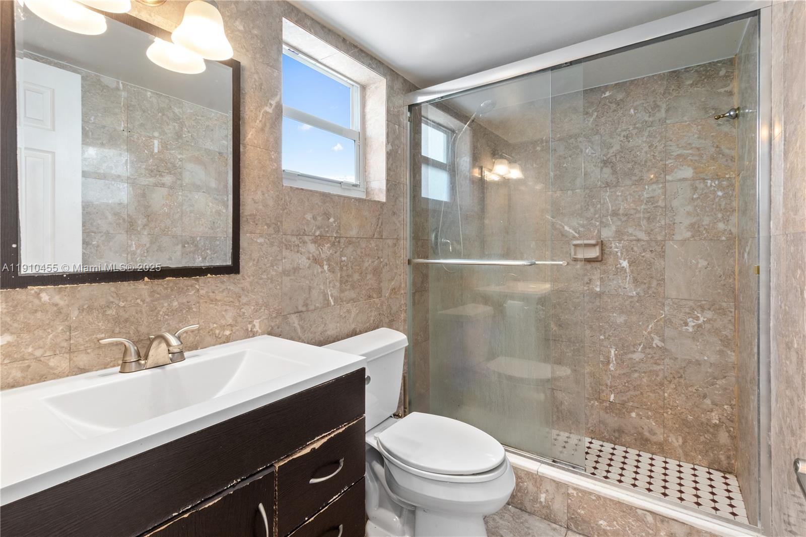 1245 West Avenue, Unit 502 Miami Beach, FL 33139 - Photo 6 of 17 a bathroom with a sink shower and a toilet