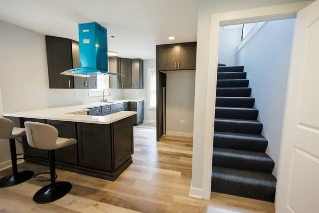 a kitchen with cabinets and chairs