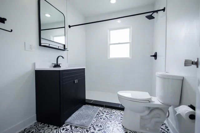 a bathroom with a sink a toilet and mirror