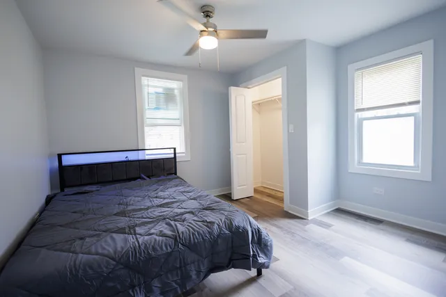 a bedroom with a bed and a chandelier fan