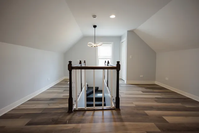 a view of staircase with railing stairs and a chandelier fan