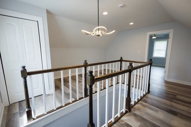 a view of a hallway with wooden floor and stairs