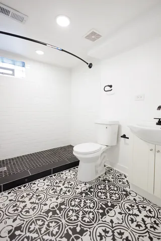 a bathroom with a sink a toilet and a mirror