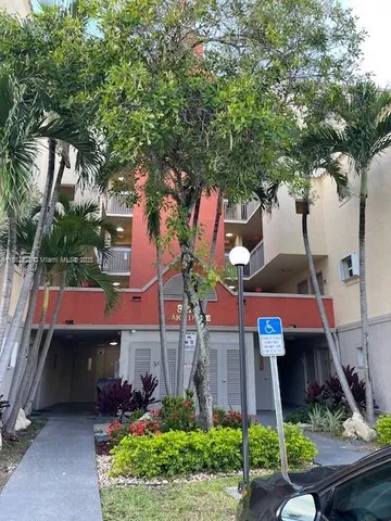 a front view of a house with a garden and tree
