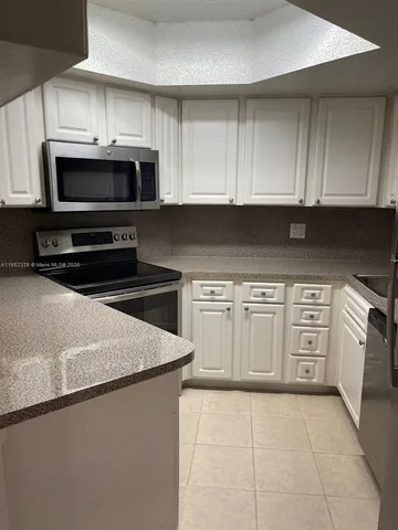 a kitchen with stainless steel appliances granite countertop a stove a microwave and a sink