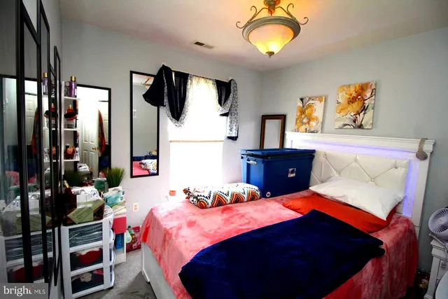 a bedroom with a bed and a flat tv screen on dresser
