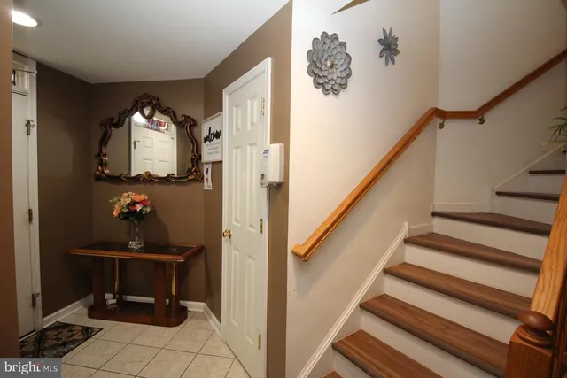 a view of a hallway with wooden floor and a bathroom