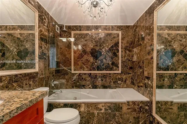 a bathroom with a granite countertop bathtub and sink
