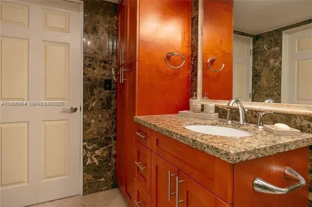 a bathroom with a granite countertop sink and a mirror
