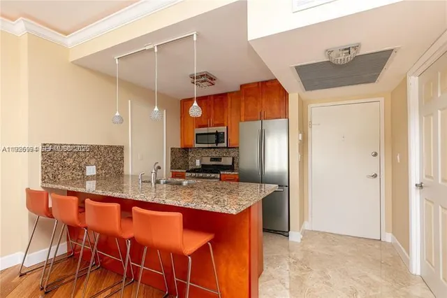 a kitchen with stainless steel appliances granite countertop a sink and a refrigerator