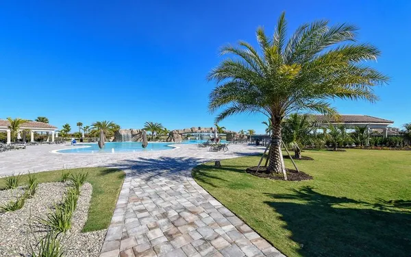 a swimming pool with outdoor seating and barbeque oven