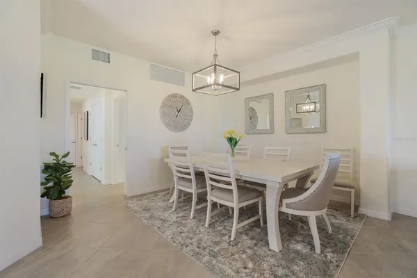 a dining room with furniture a potted plant and wooden floor