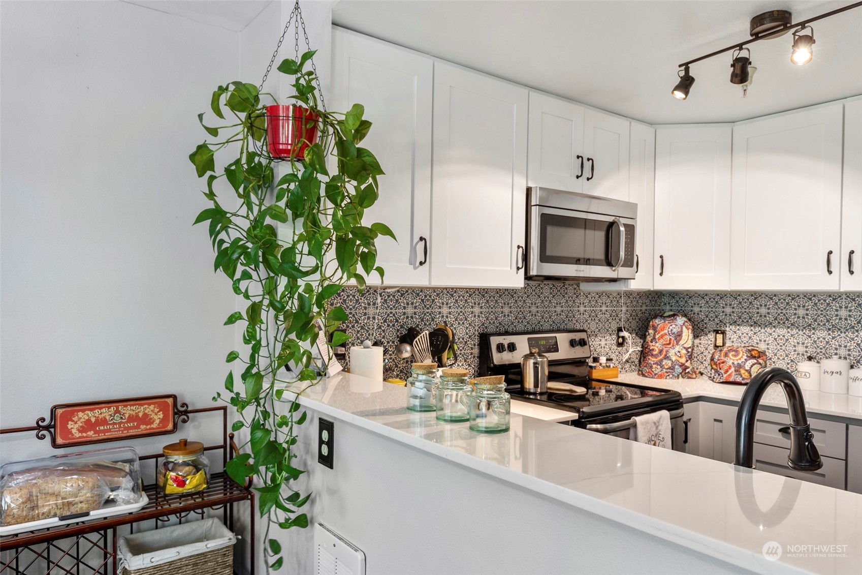 949 Aberdeen Avenue Northeast, Unit E216 Renton, WA 98056 - Photo 12 of 23 a kitchen with a potted plant on the counter and cabinets