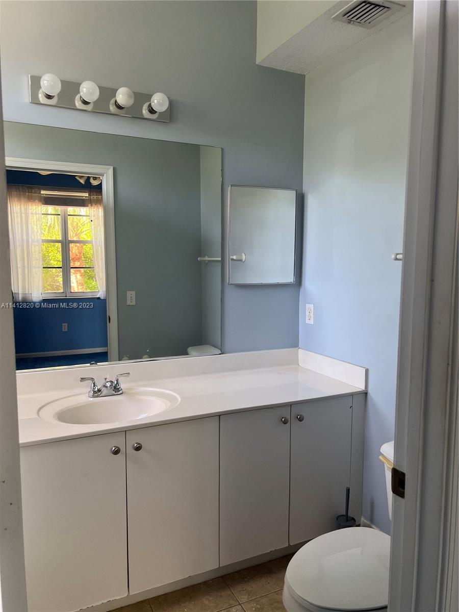 4812 Central Boulevard, Unit 20 Jupiter, FL 33458 - Photo 16 of 24 a bathroom with a sink a toilet and mirror