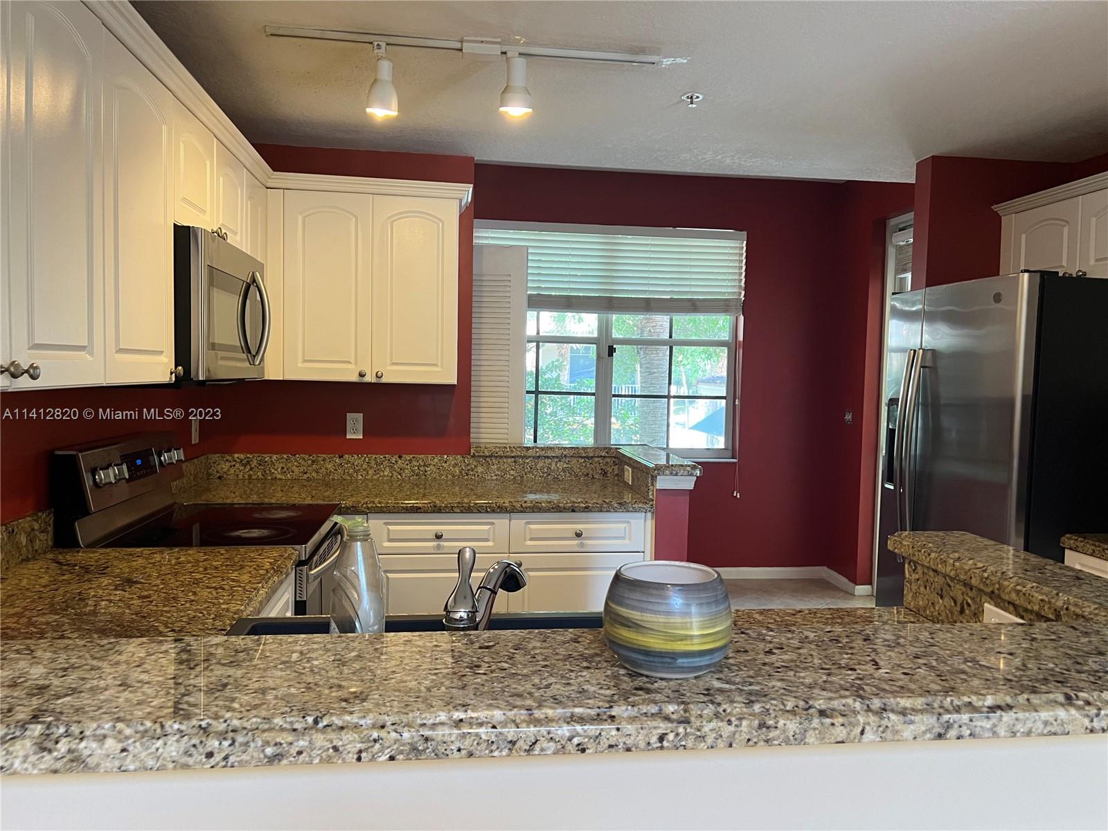 4812 Central Boulevard, Unit 20 Jupiter, FL 33458 - Photo 6 of 24 a kitchen with a stove a sink and a refrigerator