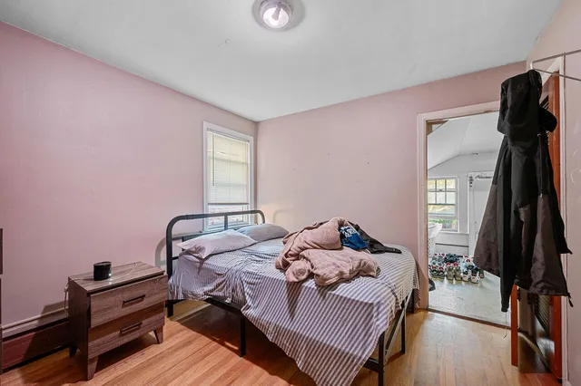 a bedroom with a bed and a flat tv screen on a dresser
