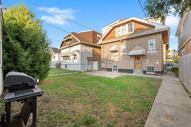 a view of a brick house with a large windows and a yard