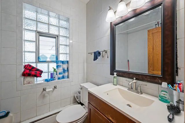 a bathroom with a sink vanity mirror and toilet