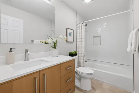 a bathroom with a granite countertop sink toilet a mirror and shower