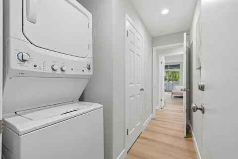 a view of washer and dryer with bathroom in the background
