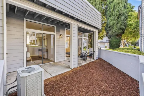 a view of a patio with table and chairs and wooden fence