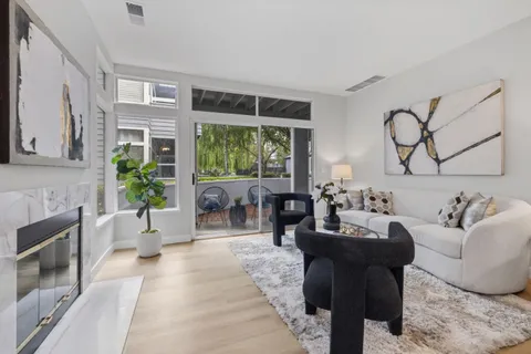a living room with furniture large window and plants
