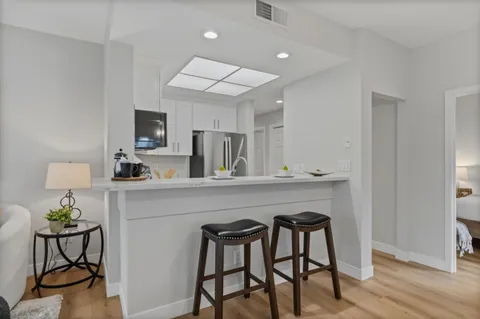 a kitchen with a table chairs refrigerator and cabinets