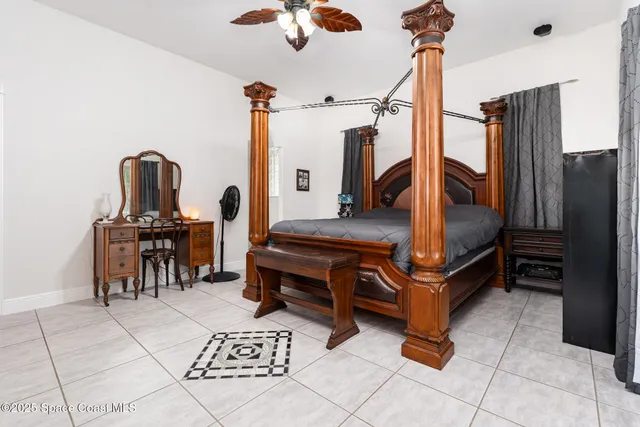 a spacious bedroom with a bed and a flat screen tv