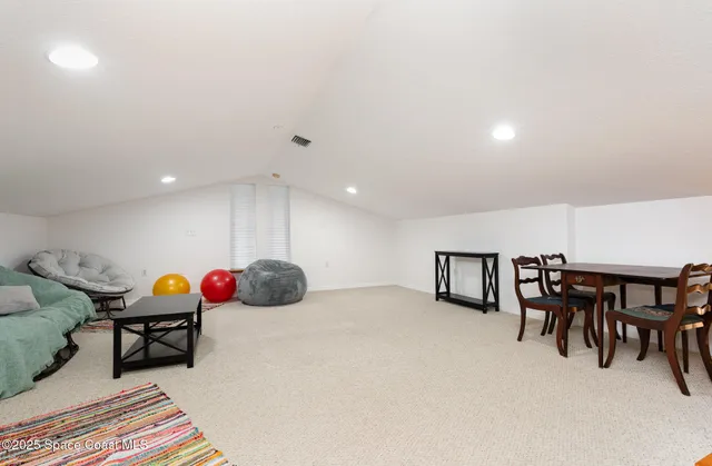 a living room with furniture a flat screen tv and a table