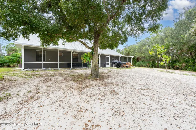 an aerial view of a house with a yard and lake view