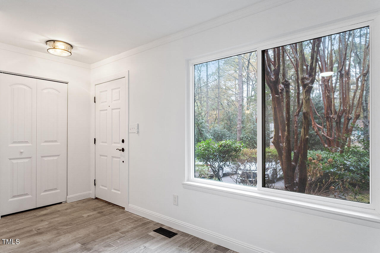 1016 North Bend Drive Raleigh, NC 27609 - Photo 17 of 36 a view of an empty room with wooden floor and a window