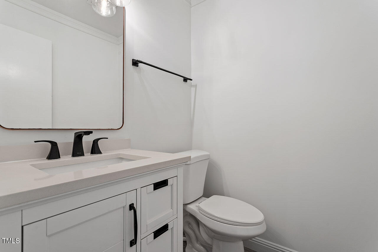 1016 North Bend Drive Raleigh, NC 27609 - Photo 24 of 36 a bathroom with a granite countertop toilet sink and mirror