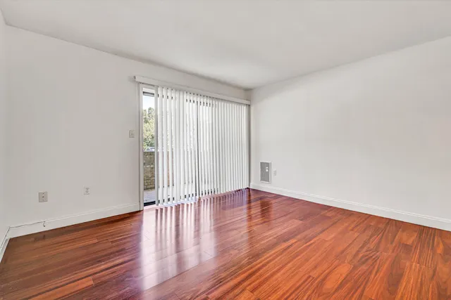 a view of an empty room with wooden and a window